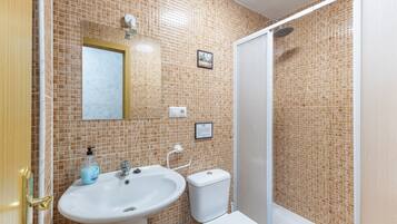 Une salle de bain avec un lavabo, des toilettes et une douche.