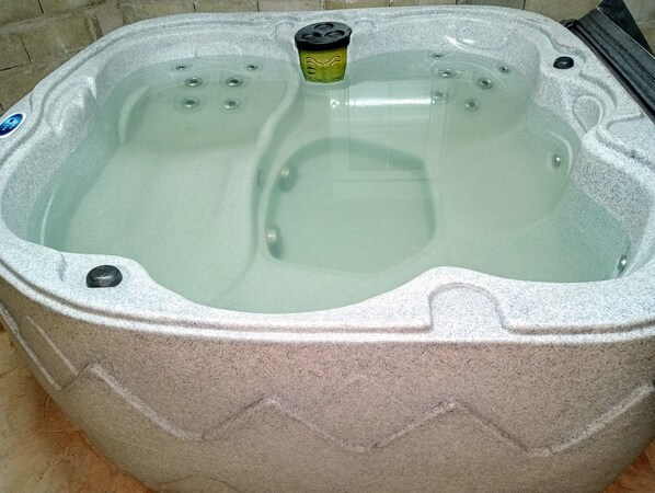 Ein Whirlpool mit Bedienfeld, integrierten Düsen und einer strukturierten Außenwand.