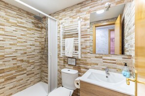 Ein Badezimmer mit Dusche, Toilette, Waschbecken und Handtuchhalter.
