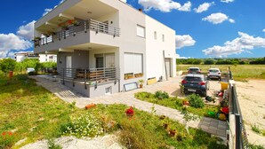A two-story modern house with a balcony, a garage, and a garden with potted plants. - Apartment 2341/115071 (Istria - Fažana), 500m from the beach (Fažana)