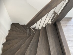 A modern staircase with wooden steps and metal railings. - "Meeresjuwel" Amberly - "Amberly - Amberly" at the Meeresjuwel house! (Dahme)