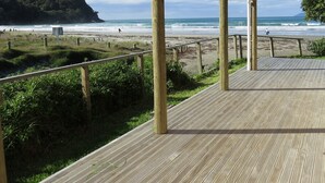 A wooden deck with a view of the beach and ocean. - Absolute beachfront! Sleeps 12+
Built 2011 (Waihi Beach)