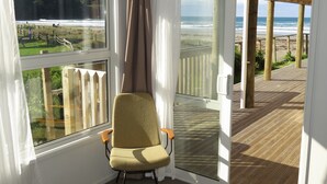 A room with a view of the beach, a chair, and a wooden deck. - Absolute beachfront! Sleeps 12+
Built 2011 (Waihi Beach)