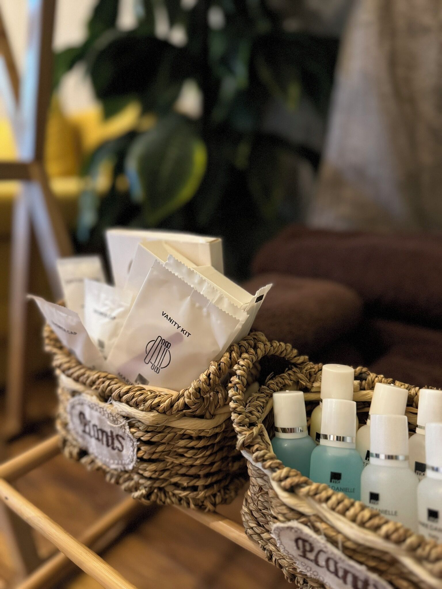 Una cesta de mimbre con un neceser y varias botellas de productos para el cuidado de la piel.