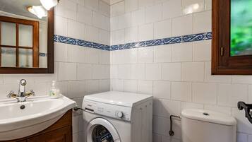 Un baño con lavadora, lavabo e inodoro.