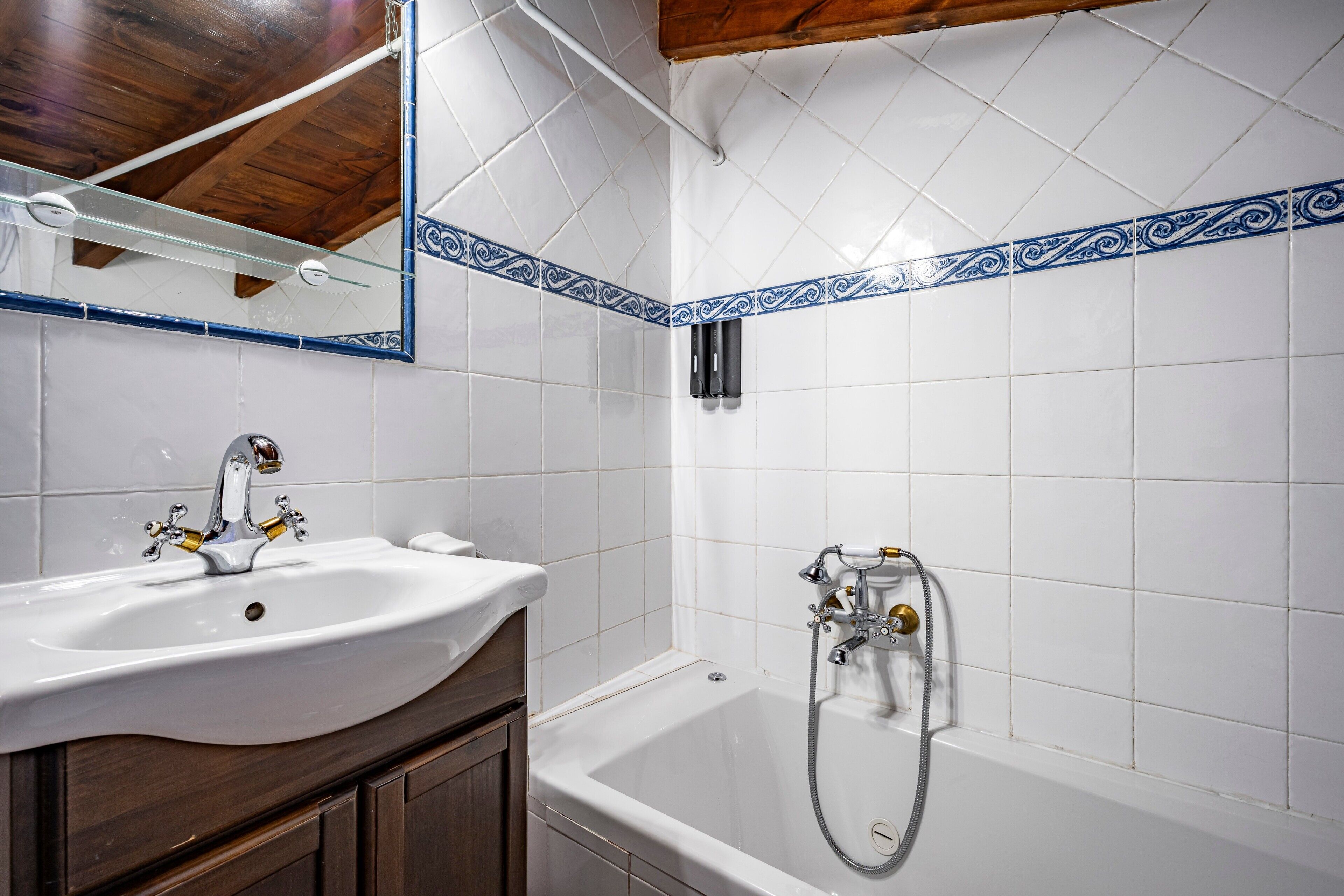 Een badkamer met een wit wastafel, een bad en een douche.