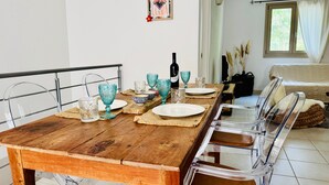 A dining area with a wooden table, clear chairs, and various glassware. - Holiday Home 'Casa Guilia' with Private Terrace, Wi-Fi and Air Conditioning (Valledoria SS)