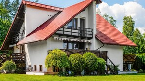 Un bâtiment à deux étages, doté d’un toit à forte pente, de grandes fenêtres et d’un balcon.