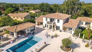 Ein Wohnhaus mit Pool, Sitzgelegenheiten im Freien und einem Garten.