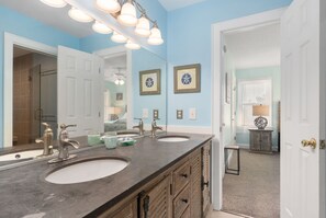 A bathroom with two sinks, a large mirror, and a vanity with drawers.
