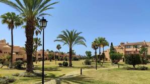 A resort with palm trees, a clear sky, and buildings with Mediterranean architecture. - Splendid duplex apartment in Estepona (Estepona)