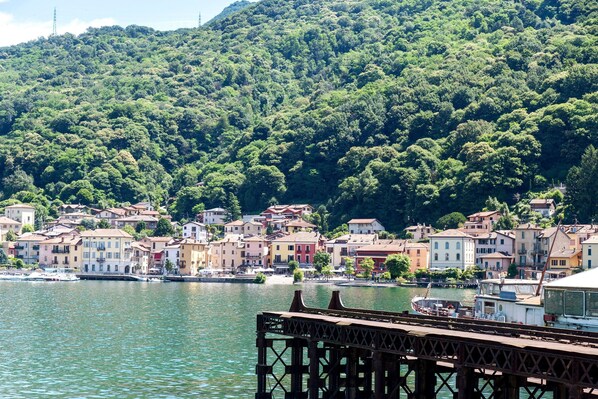 Un pueblo costero con edificios coloridos, un muelle y una ladera.
