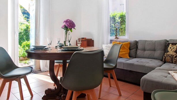 Un comedor con una mesa, sillas y un sofá.