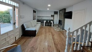 Et moderne interiør med sofa, spisebord, køkken og trappe.