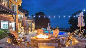 A patio area with a fire pit, outdoor seating, and a swimming pool. - Landing At The Lake: Craftsman Style Home w Pool, Hot Tub (Denver)