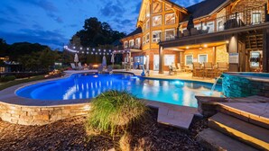A large house with a swimming pool, outdoor seating, and a stone pathway. - Landing At The Lake: Craftsman Style Home w Pool, Hot Tub (Denver)