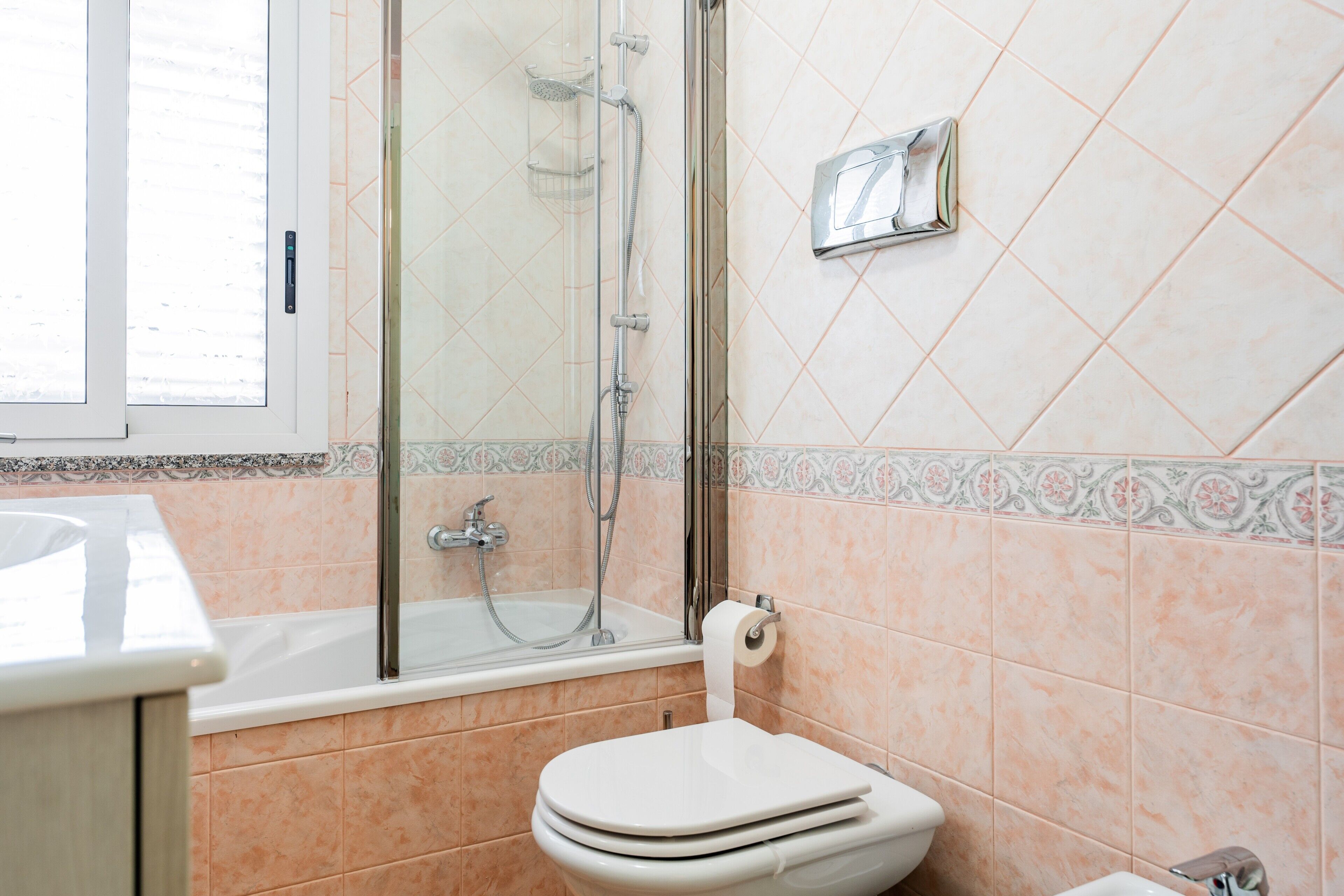 Een badkamer met een douche, toilet en wastafel.