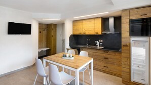 A modern kitchen with wooden cabinets, a built-in oven, and a refrigerator. - Apartment 'A Due Passi Verde' with Mountain View, Balcony and Wi-Fi (Livigno)