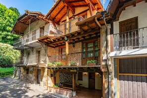 Un edificio a più piani con balconi, pareti in pietra e travi in legno.