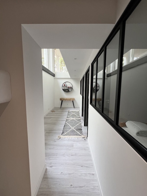A hallway with a bench, a rug, and a circular wall decoration.