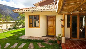 Une maison avec un toit en tuiles, une porte en bois et un petit jardin agrémenté de pas japonais.
