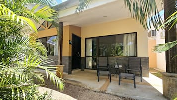 A modern building with a covered patio area featuring outdoor seating and a small table.