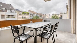 Ein Balkon mit Tisch und Stühlen mit Blick auf ein Wohngebiet.