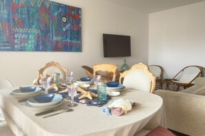A dining table set with plates, glasses, and decorative items like seashells and starfish.