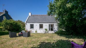 A white house with a grey roof, a small garden, and outdoor furniture. - Holiday Home 'Maison Bretonne' with Private Terrace, Private Garden and Balcony (Ploumagoar)