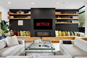 Smart-tv, eldstad, böcker och en stereo