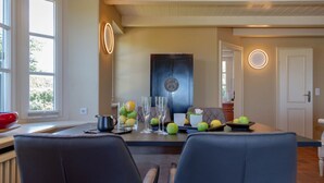A dining area with a table set for two, featuring a fruit bowl, glasses, and a pitcher. - Heefwai 2-W3 - Holiday apartment "Heefwai 2 W3" in Morsum (Morsum)