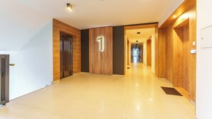 Un pasillo moderno de hotel con un revestimiento de madera, un letrero con el número '1' y un piso de baldosas limpias.