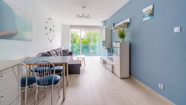 Cocina moderna con zona de comedor, ventanas amplias y vistas al verdor.