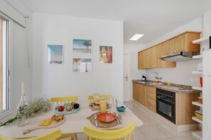 Une cuisine moderne avec des meubles en bois, un coin repas avec des chaises jaunes et une table mise pour le repas.