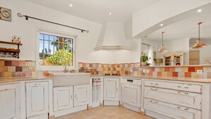 A kitchen with white cabinetry, a window with a view, and a tiled backsplash.