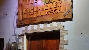 A wooden door with a decorative archway and a sign above it. - Back Packer (Ibarra)