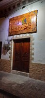 Una puerta de madera con un arco decorativo y un letrero encima.