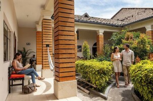 Un edificio con un porche cubierto, columnas de madera y un sendero que lleva a una puerta.