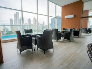Una sala riunioni moderna con ampie finestre, mobili in vimini e vista sulla città.