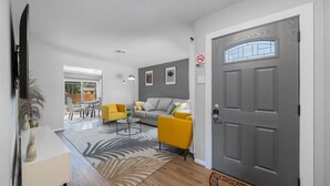 A modern living room with a sofa, yellow armchairs, and a coffee table. - 3-Bed Haven - 6 pple Hot tub, King bed, Pool & ping pong table, Grill, Fire pit (Richardson)