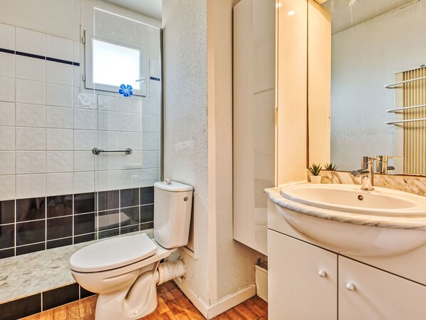 Une salle de bain moderne équipée de toilettes, d’un lavabo et d’une douche.