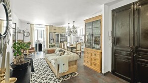 A spacious living room with a sofa, dining table, and kitchen area. - Upstays Banane Center 80m² Apartment (Cannes)
