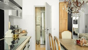A modern kitchen with a dining area, stainless steel appliances, and a chandelier. - Upstays Banane Center 80m² Apartment (Cannes)