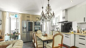 A modern kitchen with a dining area, stainless steel appliances, and a chandelier. - Upstays Banane Center 80m² Apartment (Cannes)