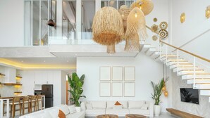 A spacious living area with a white sofa set, a wooden coffee table, and a large plant. - Villa Belga (Canggu)