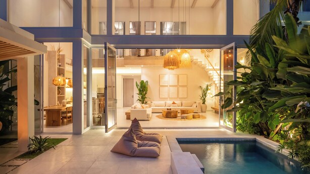 A modern house with a pool, glass doors, and a dining area. - Villa Belga (Canggu)