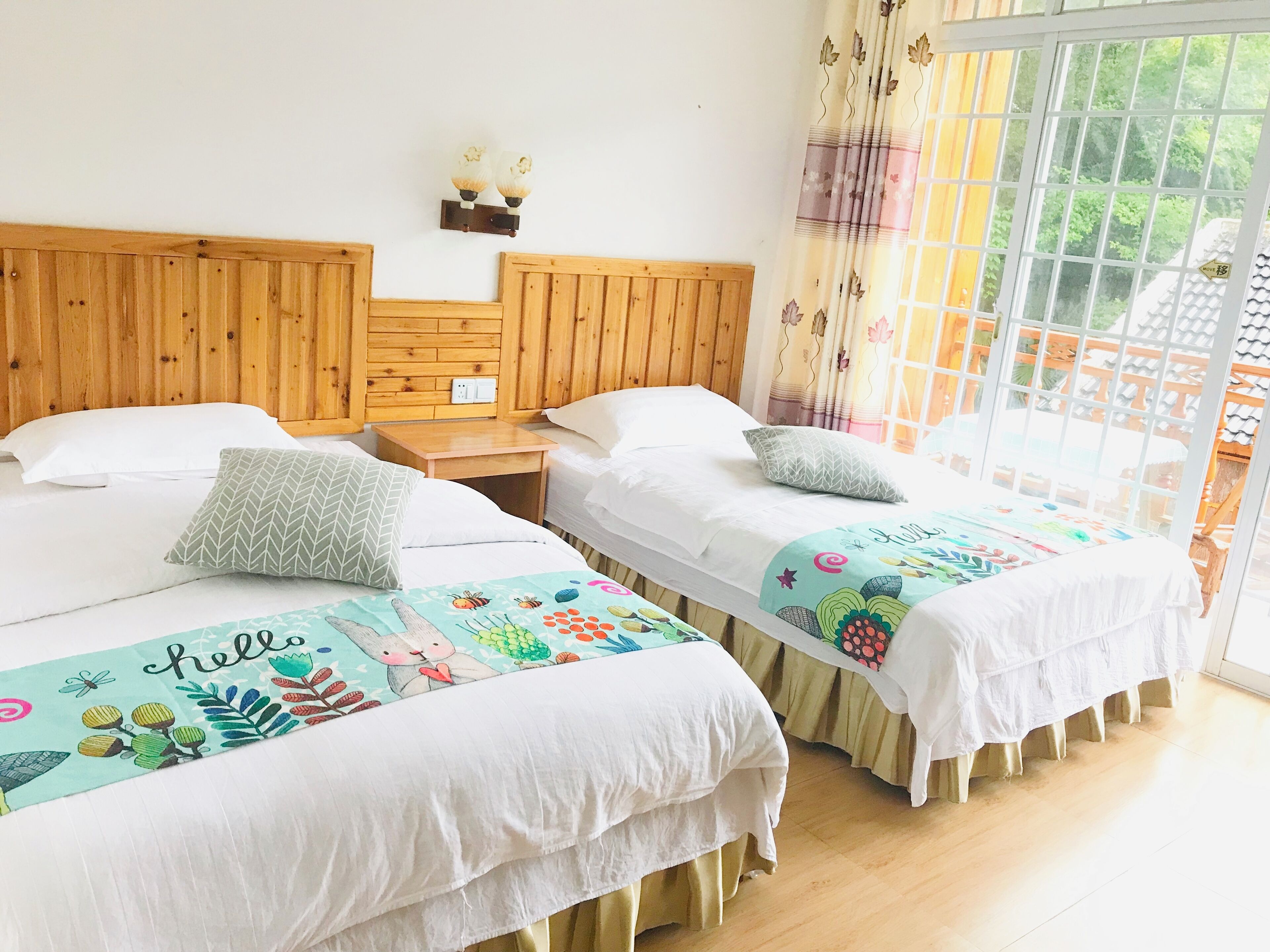 Une chambre avec deux lits, une tête de lit en bois, des tables de chevet et une fenêtre avec des rideaux.