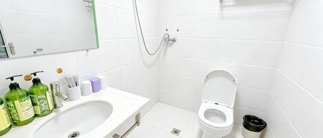 Un baño moderno con lavamanos doble, inodoro y ducha.