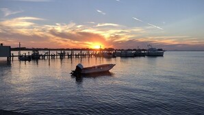 Een jachthaven met boten afgemeerd aan houten steigers in de zonsondergang.