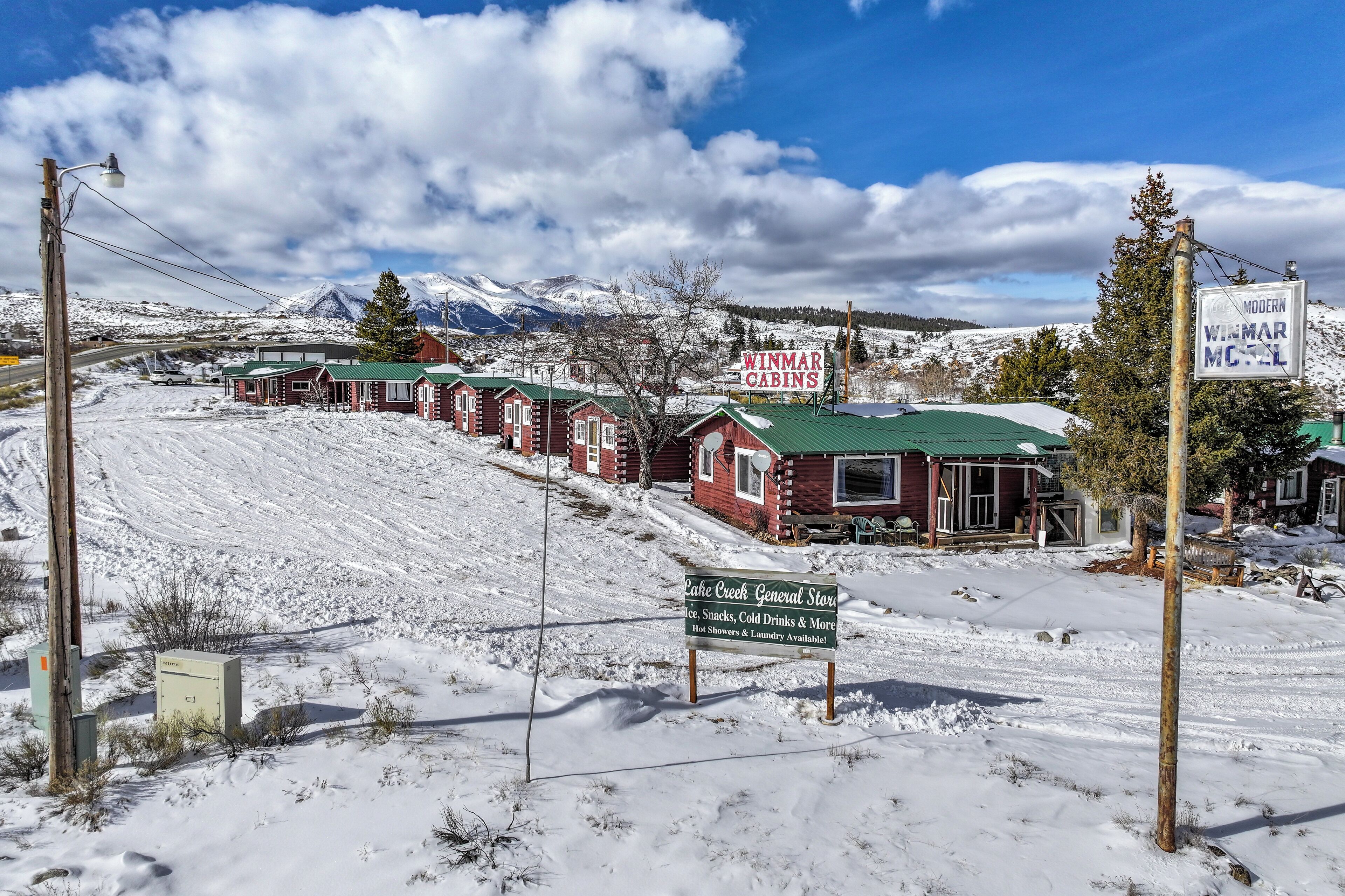 Schneebedeckte Landschaft mit Hütten und einem Schild für das Winmar Motel.